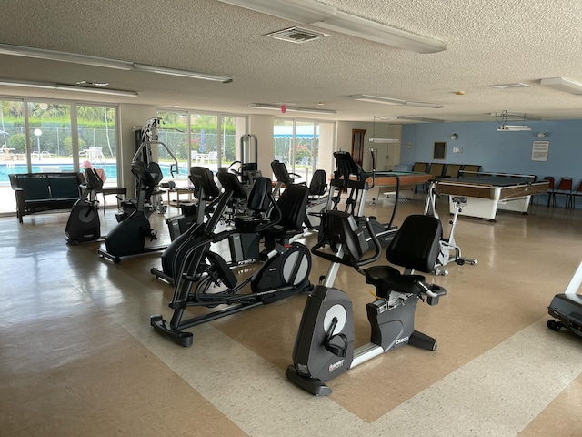 gym with a healthy amount of sunlight, visible vents, and a textured ceiling