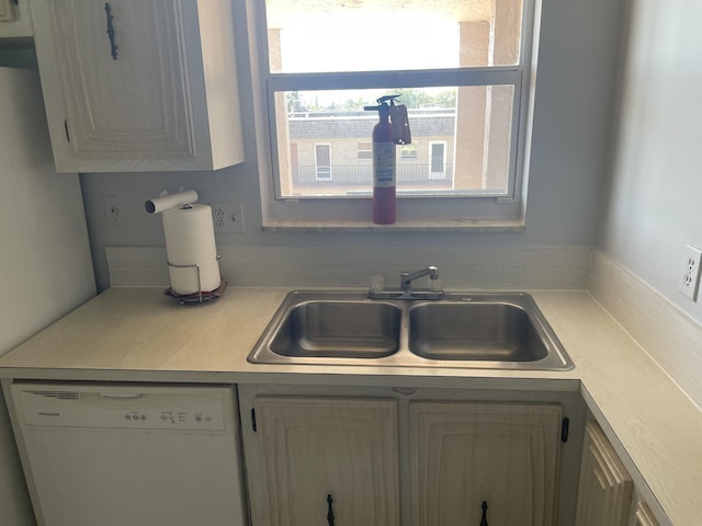 kitchen featuring dishwasher, light countertops, and a sink