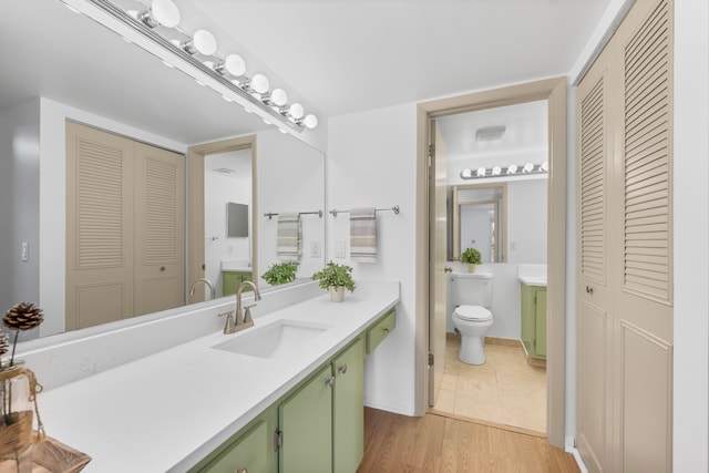 bathroom with hardwood / wood-style flooring, vanity, and toilet