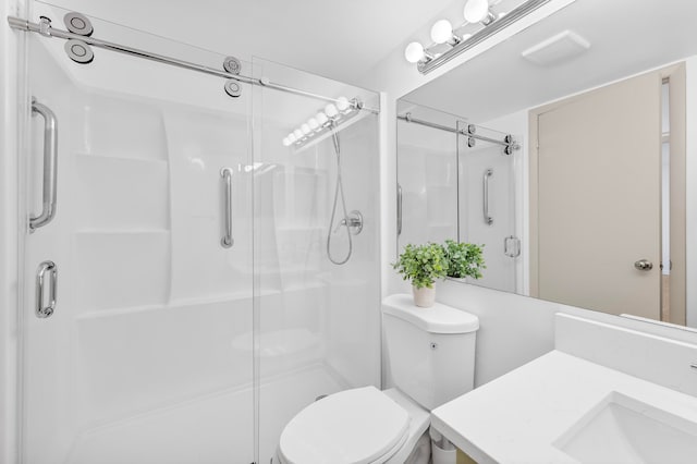 bathroom with vanity, toilet, and a shower with shower door