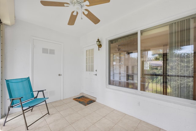 unfurnished sunroom featuring ceiling fan