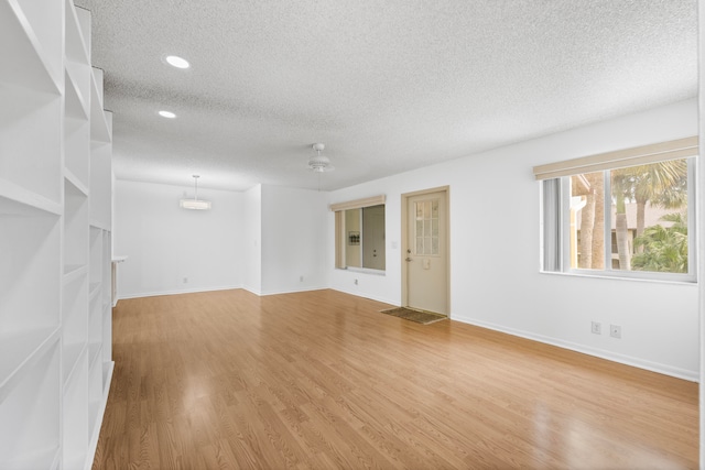 unfurnished living room featuring wood-type flooring and a textured ceiling