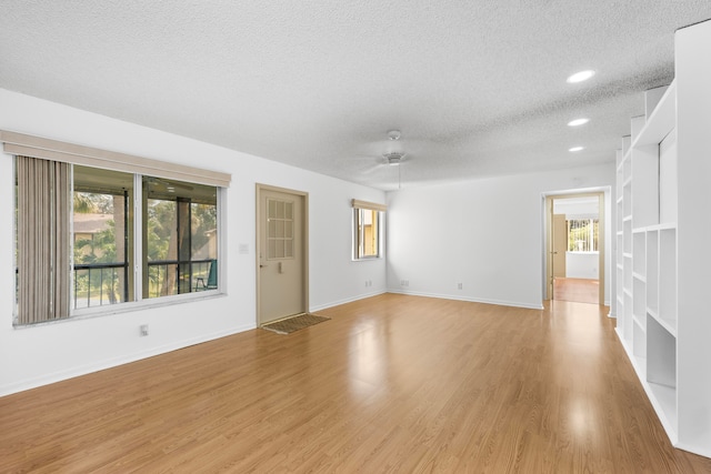 unfurnished room featuring a textured ceiling, light hardwood / wood-style floors, and ceiling fan