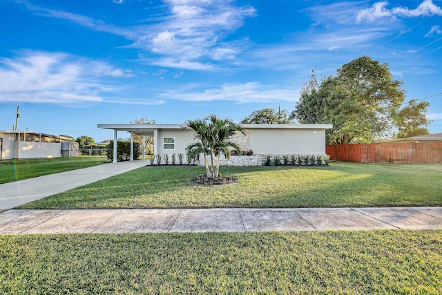 ranch-style house with a carport and a front lawn