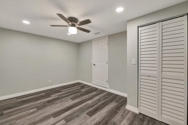 unfurnished bedroom featuring ceiling fan, dark wood-type flooring, and a closet