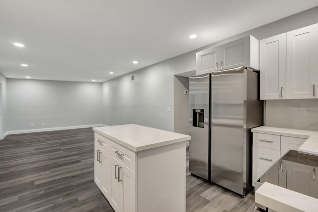 kitchen with white cabinetry, a center island, dark wood-type flooring, and stainless steel refrigerator with ice dispenser