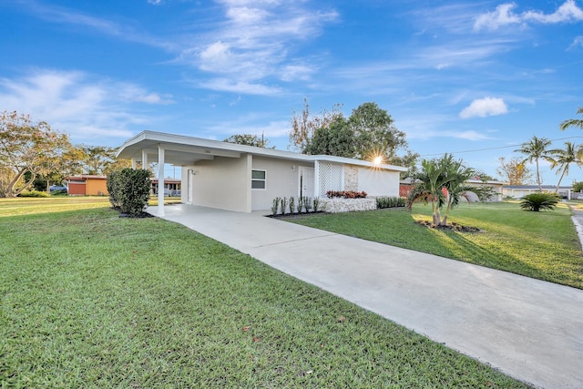 ranch-style home featuring a front lawn and a carport