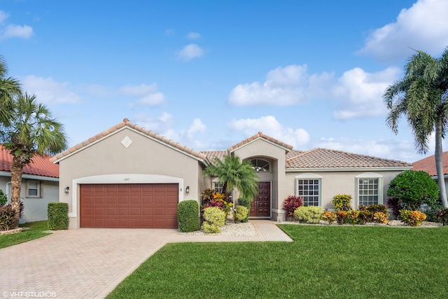 mediterranean / spanish-style house featuring a front yard and a garage