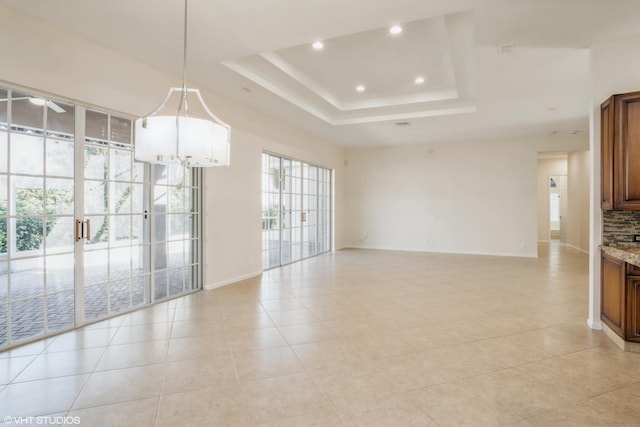 interior space featuring a raised ceiling, a wealth of natural light, and light tile patterned flooring