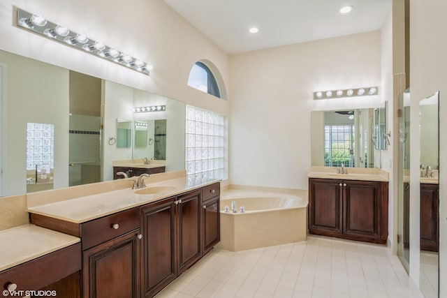 bathroom with tile patterned floors, vanity, a towering ceiling, and independent shower and bath