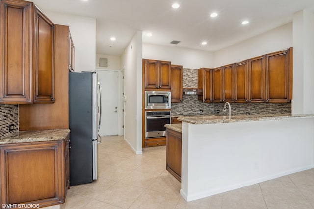 kitchen with kitchen peninsula, light stone countertops, tasteful backsplash, stainless steel appliances, and light tile patterned flooring