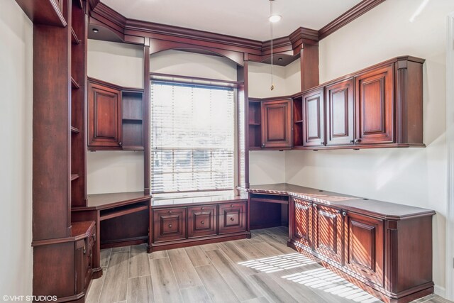 unfurnished office featuring light wood-type flooring and ornamental molding