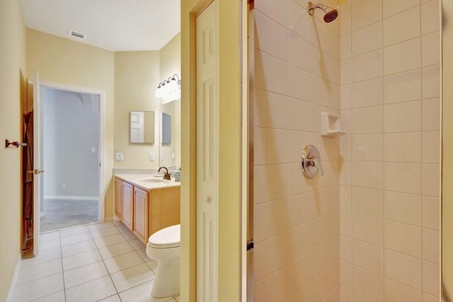 bathroom with a tile shower, tile patterned floors, vanity, and toilet