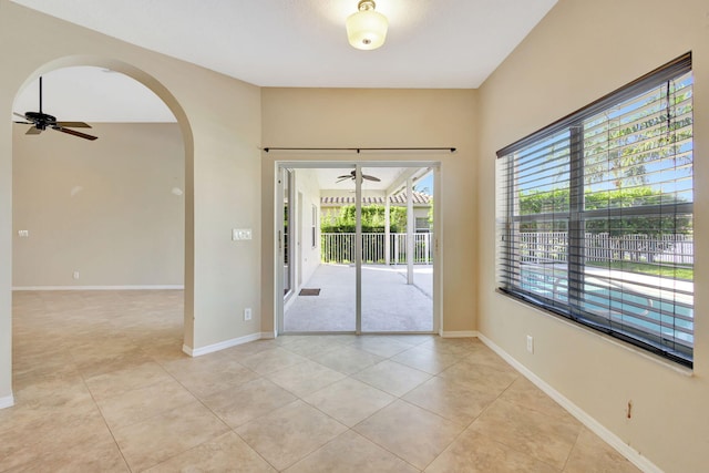 tiled empty room featuring ceiling fan