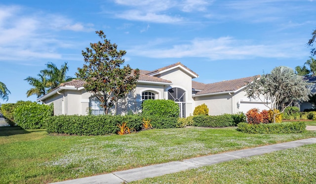 mediterranean / spanish home with a garage and a front lawn