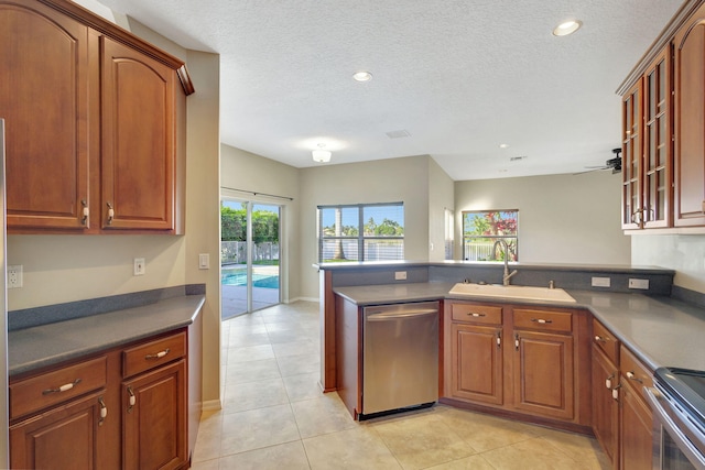 kitchen with dishwasher, stove, light tile patterned flooring, and sink