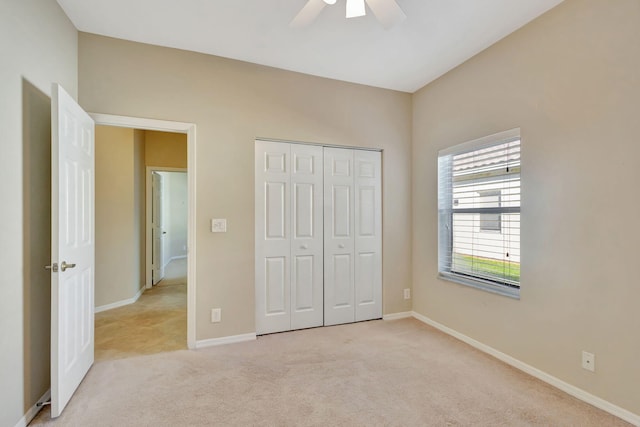 unfurnished bedroom with a closet, ceiling fan, and light colored carpet