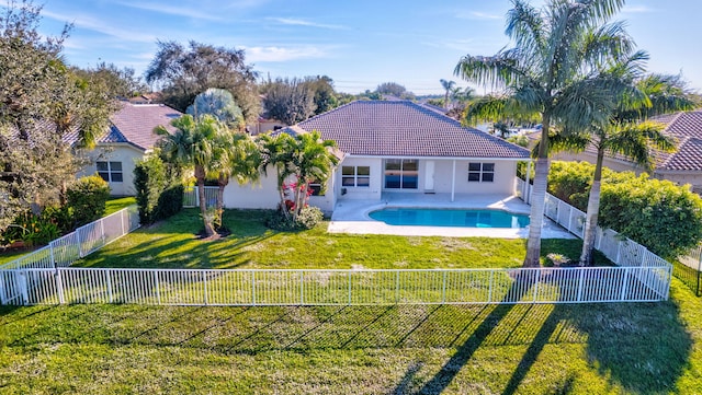 rear view of house featuring a lawn, a patio area, and a fenced in pool