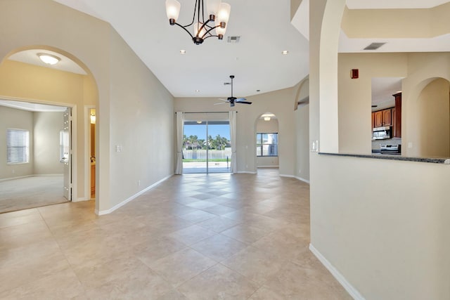 interior space with light tile patterned flooring and ceiling fan with notable chandelier