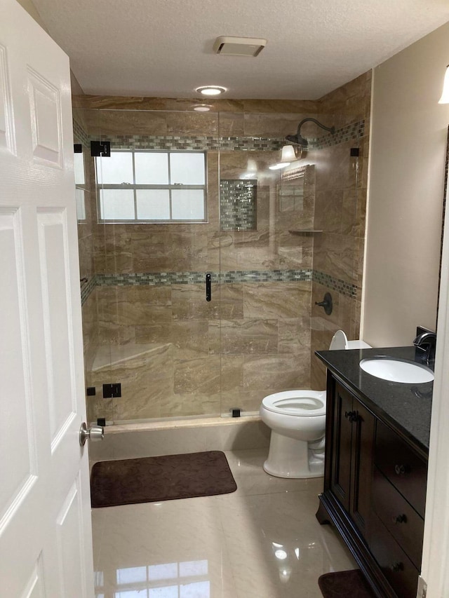 bathroom featuring tile patterned flooring, a textured ceiling, an enclosed shower, toilet, and vanity