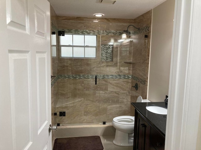 bathroom featuring vanity, toilet, and a shower with door