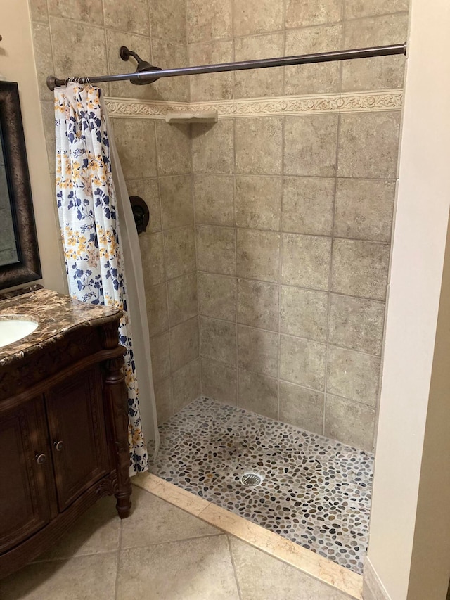 bathroom with tile patterned flooring, vanity, and walk in shower