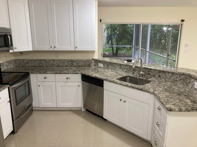 kitchen featuring white cabinets, stainless steel appliances, stone counters, and sink