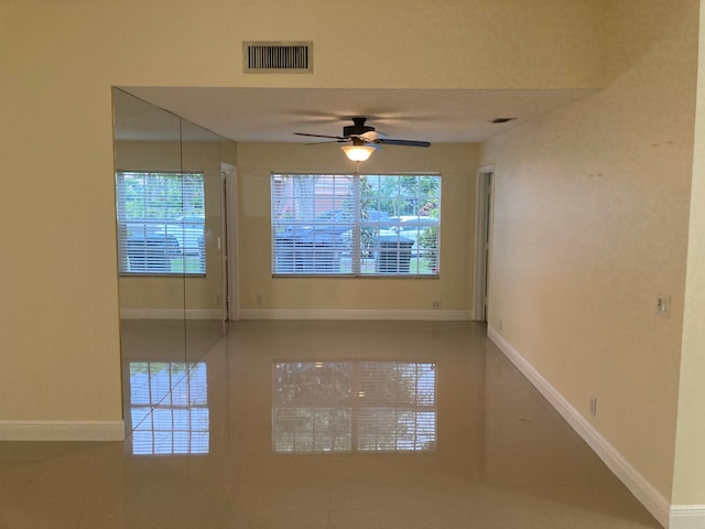 spare room with ceiling fan and a healthy amount of sunlight