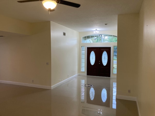 entryway with ceiling fan and a textured ceiling