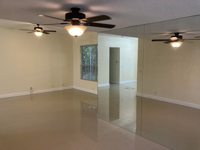 tiled empty room featuring ceiling fan