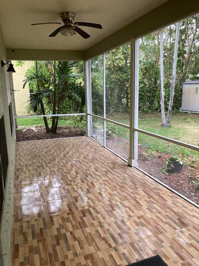 unfurnished sunroom featuring ceiling fan