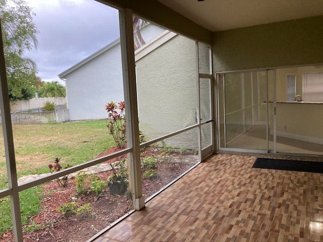 unfurnished sunroom with beam ceiling