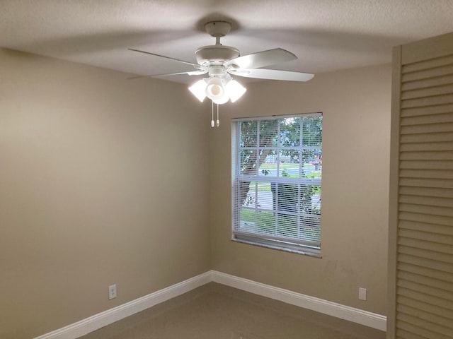 unfurnished room with ceiling fan and a textured ceiling