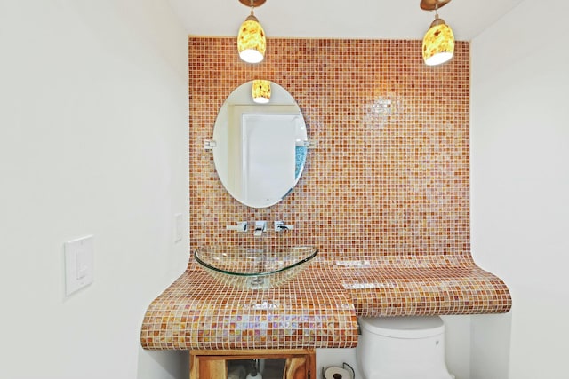 bathroom with decorative backsplash, toilet, and tile walls