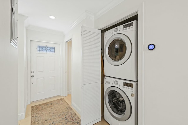 washroom featuring stacked washing maching and dryer, crown molding, and light tile patterned floors