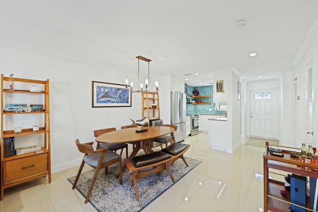 tiled dining area with crown molding and a notable chandelier