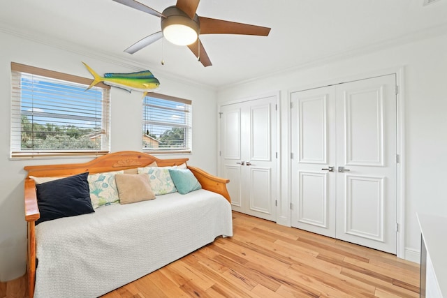 bedroom featuring multiple windows, ceiling fan, light hardwood / wood-style floors, and ornamental molding