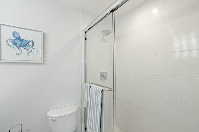 bathroom with radiator heating unit, toilet, and a shower with shower door