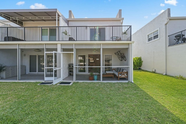 back of house with a yard, a balcony, and a sunroom