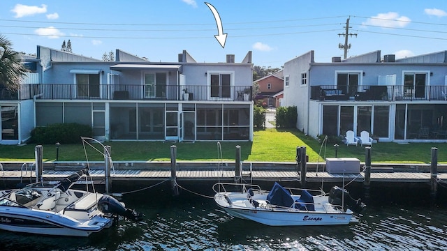 dock area featuring a yard, a water view, and a balcony