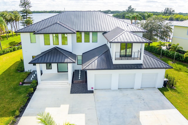 modern farmhouse style home with a garage, a balcony, and a water view