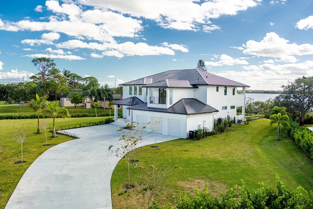 view of home's exterior featuring a lawn, a garage, and a water view