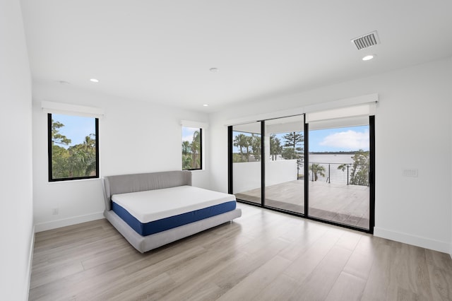 bedroom featuring light wood-type flooring and access to outside