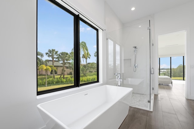 bathroom featuring wood-type flooring, separate shower and tub, and a healthy amount of sunlight