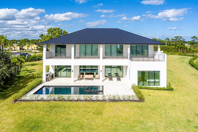 rear view of house with a lawn, an outdoor living space, a balcony, and a patio