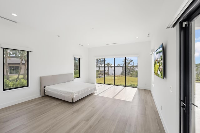 bedroom featuring access to exterior and light hardwood / wood-style flooring