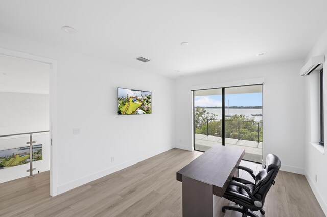 office space with light hardwood / wood-style flooring and a wall mounted air conditioner