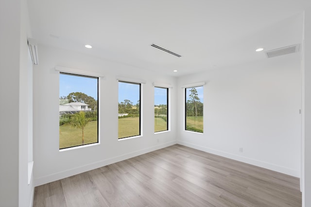 empty room featuring light wood-type flooring and a healthy amount of sunlight