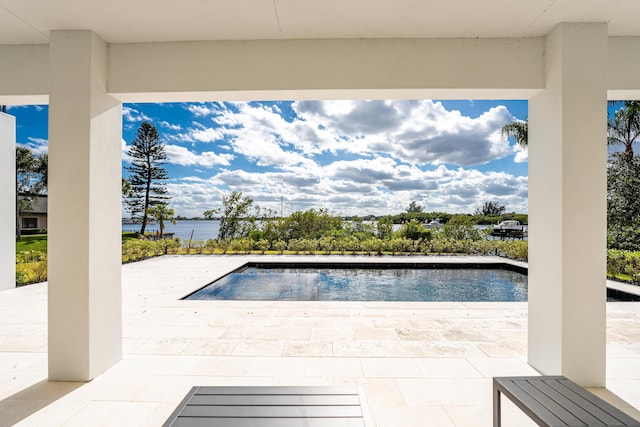 view of swimming pool featuring a water view and a patio