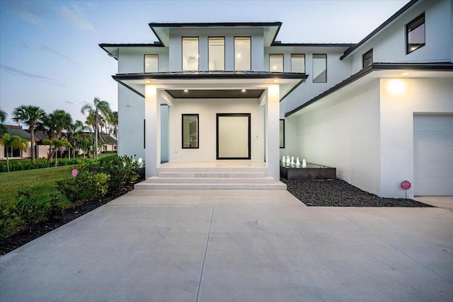 exterior entry at dusk featuring a garage